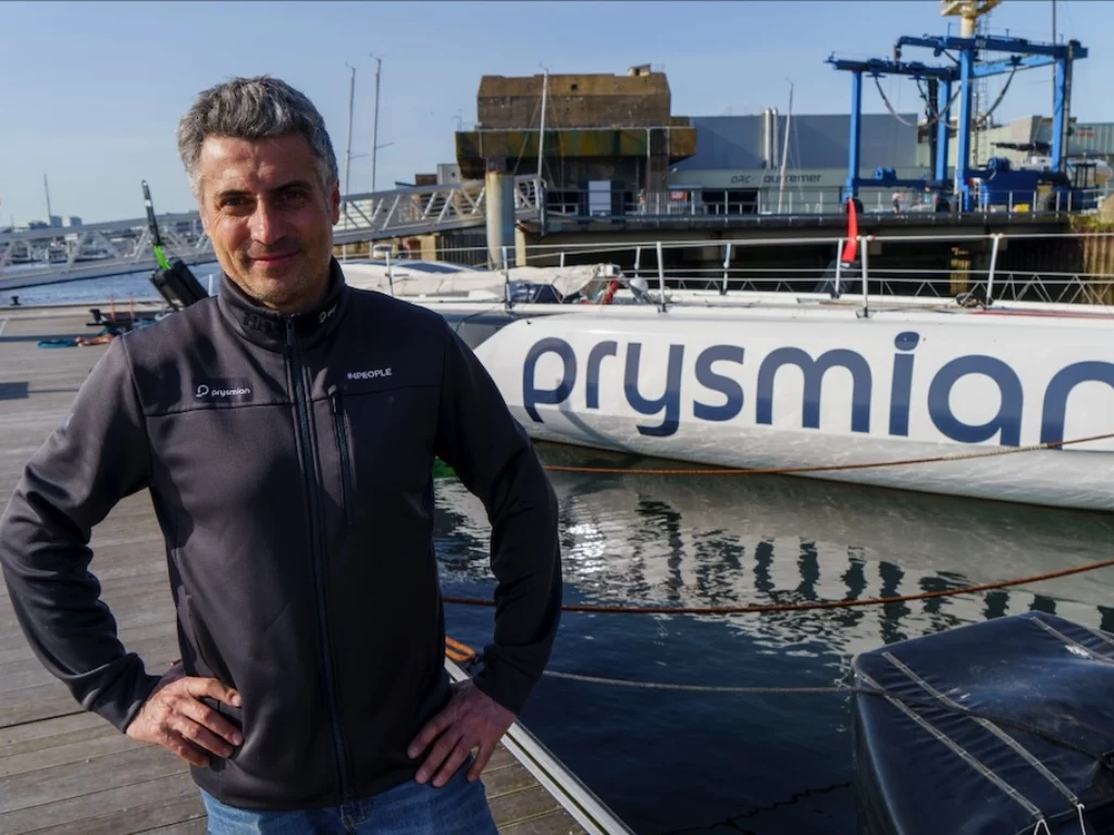 Giancarlo Pedote accanto all'IMOCA Prysmian nel porto di Lorient. Photo @Matteo Mangherini / NOESIS / Prysmian
